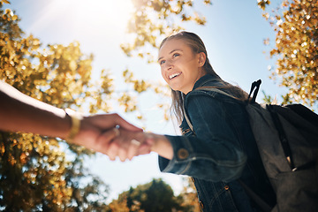 Image showing Woman, smile and holding hands in nature with backpack for travel, trip or couple adventure. Happy female touching hand smiling in park with bag for summer bonding, traveling or outdoor holiday break