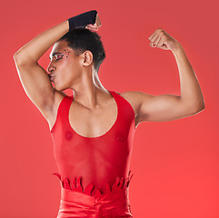 Image showing Man, studio and arm muscle kiss with wrestling, punk costume and makeup for lgbt aesthetic by red background. Young bodybuilder, gen z gay and fitness with strong body, self care and pride for health