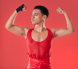 Image showing LGBTQ, flexing and empowerment of gay man or nonbinary person with fashion isolated in studio red background. Strength, queer and model with style and beauty in the gen z and LGBT community pride