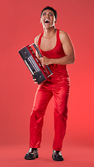 Image showing Radio, laughing and red background with a gen z man in studio listening to music for carefree fun. Transgender, non binary and laughter with a young androgynous or gay person posing for inclusion