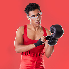 Image showing Gay man, studio and boxing glove on hand with punk costume, makeup and lgbt aesthetic by red background. Young bodybuilder, gen z fighter and fitness with strong body, self care and pride for boxer