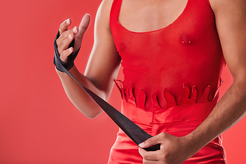 Image showing Young man and boxing wrap isolated on red background for queer fight, punk fashion and lgbtq aesthetic. Bodybuilder, self defense and model, sports person or boxer hands with fitness or martial arts
