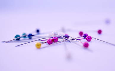 Image showing Closeup, sewing pin and design in studio by purple background for clothing manufacturing in factory. Macro, metal needles or table for fashion, clothes or workshop for tailor, designer or seamstress