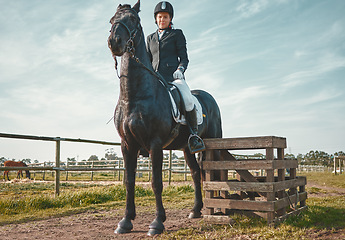 Image showing Sports, horse and equestrian with a woman jockey riding outdoor on a farm or ranch for horseback training. Nature, agriculture and field with a female athlete or rider on an animal for horesriding