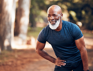Image showing Black man, break from running and relax with fitness, vitality and cardio, senior runner in the park. Exercise, earpods and listen to music for motivation, tired with endurance and health outdoor