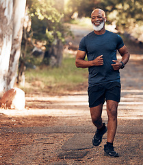 Image showing Music earphones, running and black man in nature for health, wellness and fitness. Radio, podcast and smile of happy senior athlete training, exercise and workout, cardio and jog outdoors at park.