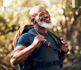 Image showing Nature, fitness and black man hiking with a backpack in a forest for exercise, health and wellness. Sports, athlete and happy senior African male hiker trekking in the woods on an adventure trail.