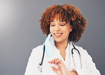 Image showing Black woman, doctor and Covid, remove face mask and health, end of pandemic and protection on studio background. Face, smile and mockup with healthcare, safety from virus and positivity with female