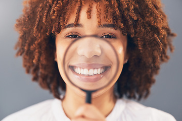 Image showing Happy, portrait and black woman with magnifying glass in a studio for a investigation or research. Happiness, smile and portrait of a young African female model with a zoom lens by a gray background.