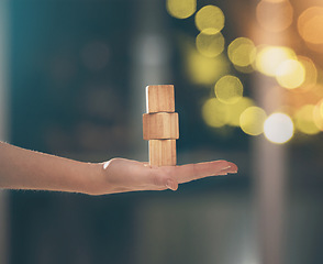 Image showing Hand, building blocks and balance with a business woman holding wood for growth on a blurred background. Investment, portfolio and stack with the foundation of a company built on financial stability
