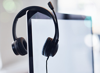 Image showing Headset, computer and mockup screen in call center for desktop support, communication or telemarketing at office. Headphones, equipment or contact us technology and tools on monitor display at work