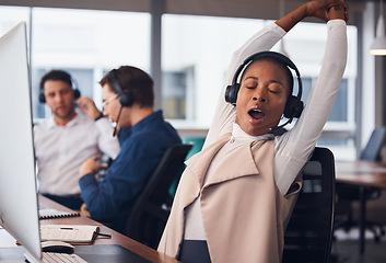 Image showing Tired black woman, yawning and stretching in call center for break in customer services or desktop support at office. African American female exhausted consultant in arm stretch from telemarketing