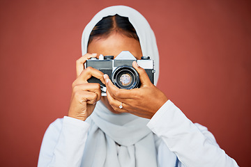 Image showing Photography, muslim woman taking picture with camera and mockup with smile isolated on red background. Creative professional lifestyle photographer in hijab, hobby or career taking photo in studio.