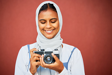 Image showing Photography, muslim woman holding camera and mockup, face with smile isolated on red background. Creative professional lifestyle photographer in hijab, hobby or career taking happy photo in studio.