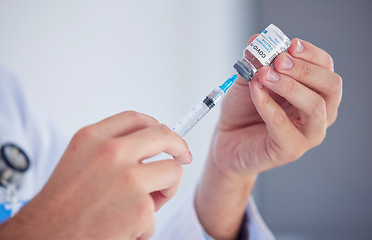 Image showing Doctor, hands and covid vaccine with syringe for cure, illness or flu shot at the hospital. Hand of medical professional extracting vial for corona virus immunization, vaccination or disease