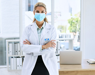 Image showing Woman, doctor and portrait with mask and arms crossed standing in confidence for healthcare by laptop office desk. Confident or proud female medical professional in medicine ready for medicare help