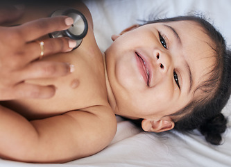 Image showing Baby, stethoscope and health and medical doctor care for happy child heart, lungs and wellness. Face and smile of toddler girl kid on a hospital bed for growth and development check with pediatrician