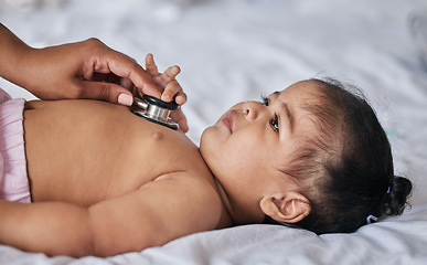 Image showing Healthcare, stethoscope and sick baby on a bed for a consultation in a children medical clinic. Infant girl kid with a cold, flu or illness getting a wellness examination or checkup at the hospital.