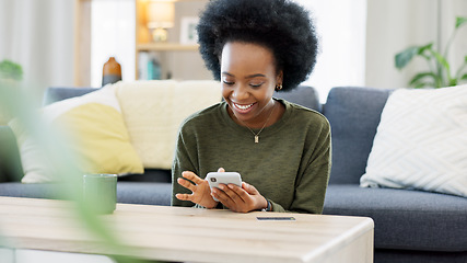 Image showing Excited black woman chatting in dating app using her phone at home. A young female online shopping happy about a purchase in her house. A lady celebrating after reading good social media news