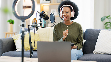 Image showing Cool afro journalist using digital tablet, talking into microphone and hosting podcast or broadcasting news while wearing headphones. Excited young woman using technology to promote on air from home