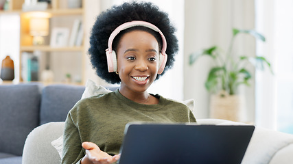 Image showing African woman using laptop and headphones while waving hello during a video call with friends. Student talking to her teacher and learning new language online during online course or private lesson