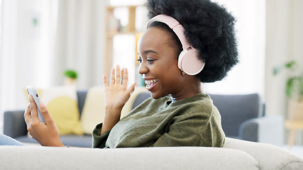 Image showing Cheerful african afro woman using phone and headphones and waving while on a video call with friends. Remote student using mobile app and talking to her teacher and learning new language online