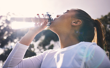 Image showing Drinking water, fitness and running with a sports woman outdoor for a cardio or endurance workout. Training, exercise and wellness with a female athlete taking a drink for hydration on a break