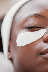 Image showing Closeup, cosmetics and black woman, eye patch and skincare for beauty, wellness and luxury treatment. Zoom, Nigerian female client and lady applying skin mask, moisturize and organic facial for shine