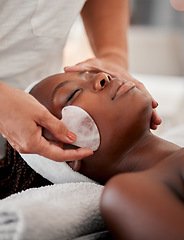 Image showing Black woman face, relax and gua sha stone spa treatment of a young female with facial. Skincare, beauty and wellness clinic with client feeling calm and zen from massage and dermatology glow