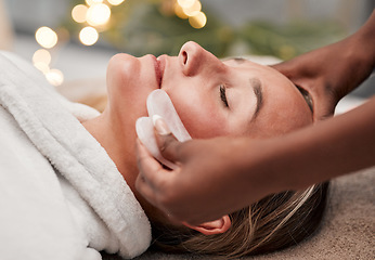 Image showing Beauty, gua sha and woman getting a facial massage for wellness, health and self care at a spa. Skincare, cosmetic and calm young female doing a luxury face treatment with rose quartz at a zen salon.