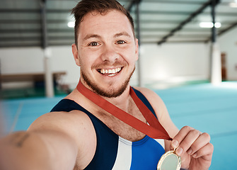 Image showing Gymnastics, fitness and male athlete taking a selfie after winning a medal in competition. Sports, smile and portrait of happy male gymnast winner taking a picture after training or practice in arena