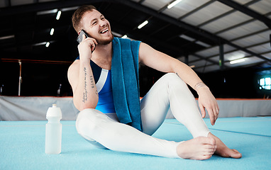 Image showing Phone call, fitness and male relaxing after training, workout or competition in arena or studio. Sports, gymnastics and happy man athlete gymnast with a smile on a mobile conversation after practice.