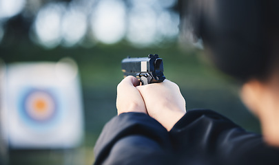 Image showing Hands, gun and aim at shooting range target with weapon outdoor for security training. Person learning defence for safety and focus for sport competition or game with handgun gear and bullseye board