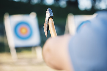 Image showing Man throwing axe at sports range, archery training or practice with board circle for goal, game and exercise. Strong person closeup with weapon for tomahawk competition, gaming park and eye target
