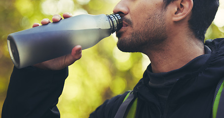 Image showing Man, hiking or drinking water in nature forest, woods or fitness environment for break, electrolytes or healthcare wellness. Hiker, backpacker or sports bottle for rest, recovery or thirsty workout