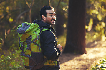 Image showing Japanese man, backpacker and hiking in forest nature, trekking woods or trees for adventure, relax workout or fitness exercise. Smile, happy and hiker walking in environment for healthcare wellness