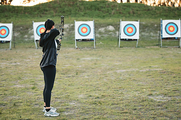 Image showing Sports, archery target and bow and arrow training for archer competition, athlete challenge or girl field practice. Shooting, objective and competitive woman focus on precision, aim or outdoor mockup