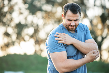 Image showing Fitness, injury and man with shoulder pain in park for running, exercise or training accident of muscle. Sport, guy and injured arm by runner in nature for cardio workout while suffering arthritis