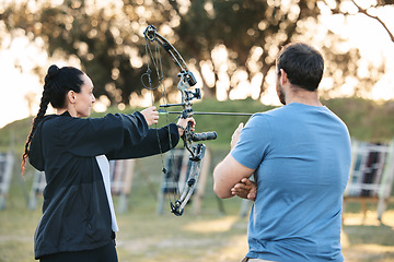 Image showing Woman, archery and target training with an instructor on a field for hobby, aim and control. Arrow, practice and archer people together outdoor for hunting, precision and weapon, shooting competition