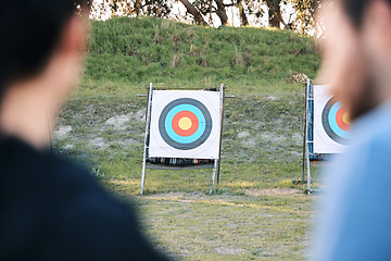 Image showing Target, archery coach or bow and arrow learning for archer competition, athlete challenge or girl training practice. Sports teacher, teaching talk or man coaching woman on precision, aim and shooting