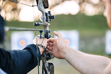 Image showing Hands, archery coach and bow or arrow learning for archer competition, athlete focus challenge or girl training practice. Teacher, teaching and man coaching woman on sports, aim and target shooting