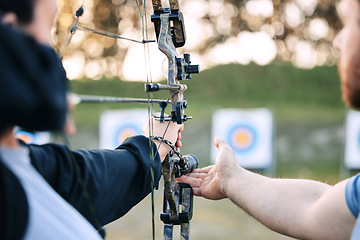 Image showing Archer hands, coach and bow or arrow learning for archery competition, athlete focus challenge or girl training practice. Teacher, teaching and man coaching woman on sports, aim and target shooting