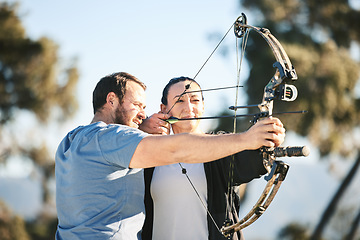 Image showing Archery, shooting range and sports training to aim with a woman and man outdoor for target practice. Archer and athlete person with focus on field for competition or game to shoot arrow for action