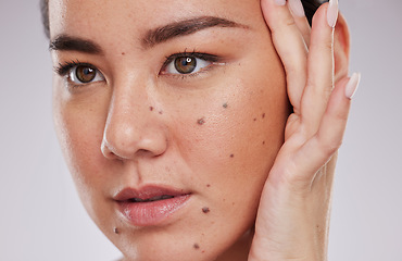 Image showing Beauty, face and skincare of a woman in studio for makeup, dermatology and cosmetics for skin glow. Aesthetic asian model person with hand to show mole and facial self care for health and wellness