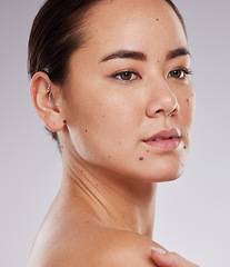 Image showing Beauty, skincare and face of a woman in studio dermatology and cosmetics for skin glow. Aesthetic asian model person with makeup shine, mole and facial self care for wellness on grey background