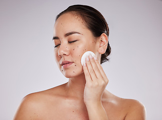 Image showing Face, skincare cotton and woman with eyes closed in studio isolated on a gray background. Makeup hygiene, beauty aesthetics and young female model with facial pad or product for cleaning cosmetics.