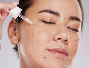 Image showing Face, eyes closed and skincare of woman with serum in studio isolated on a gray background. Dermatology skin, beauty cosmetics and female model apply hyaluronic acid, essential oil or retinol product
