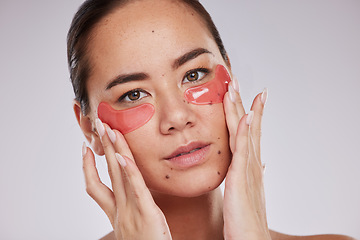 Image showing Face, skincare and woman with eye patches in studio isolated on a gray background. Dermatology portrait, cosmetics and young female model with facial pads or products for skin treatment and beauty.