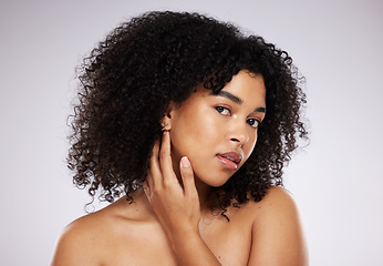 Image showing Skincare, looking and portrait of a black woman feeling face isolated on a grey studio background. Beauty, African and model touching skin to check for acne, grooming and routine on a backdrop