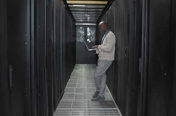Image showing Laptop, network and data center with IT black man for research, engineer working in dark server room. Computer, cybersecurity and analytics with male programmer problem solving or troubleshooting
